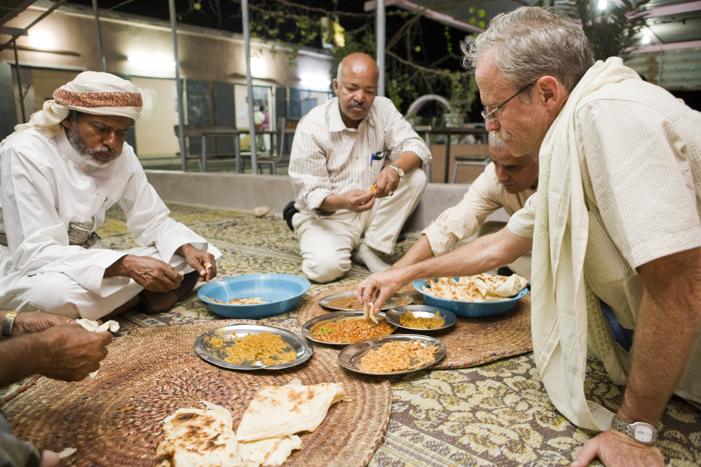 Arabian Leopard (Panthera pardus nimr) researcher David Stanton eating local food with Yousuf Mohageb, Mohammed Shamsan, and the minister of environment, Yemen