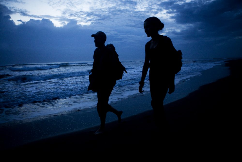 Jaguar (Panthera onca) biologists, Stephanny Arroyo-Arce and Ian Thomson, walking down beach to check for predated sea turtles at dawn, Coastal Jaguar Conservation Project, Tortuguero National Park, Costa Rica